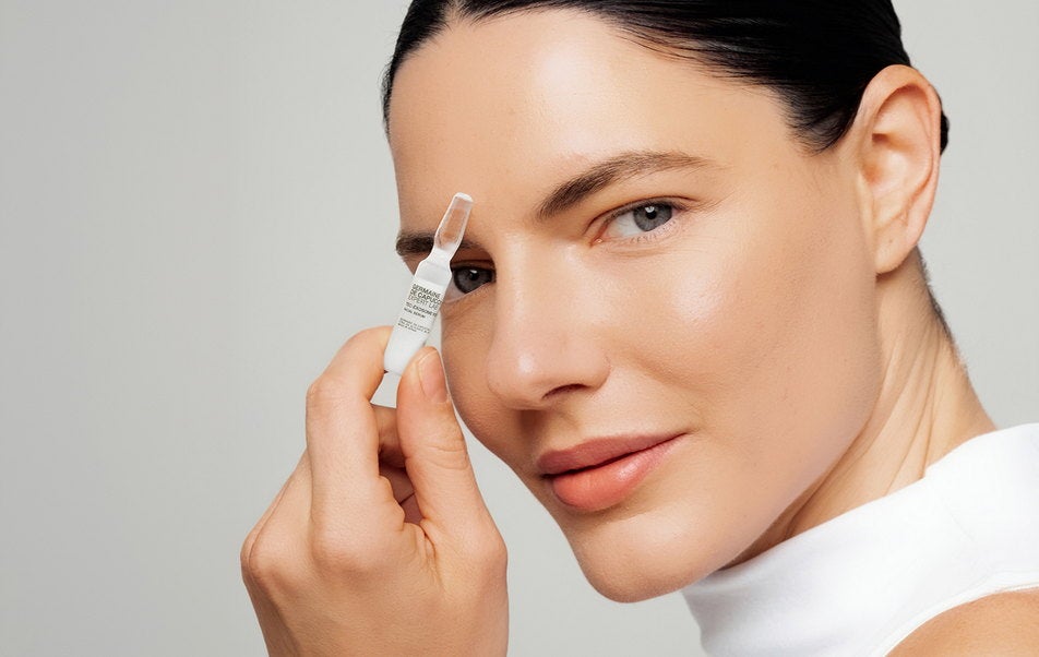 Mujer aplicándose la ampolla Tec-Exosome PDRN+HA en el rostro