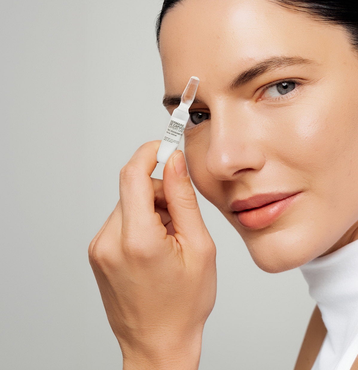 Mujer aplicándose la ampolla Tec-Exosome PDRN+HA en el rostro