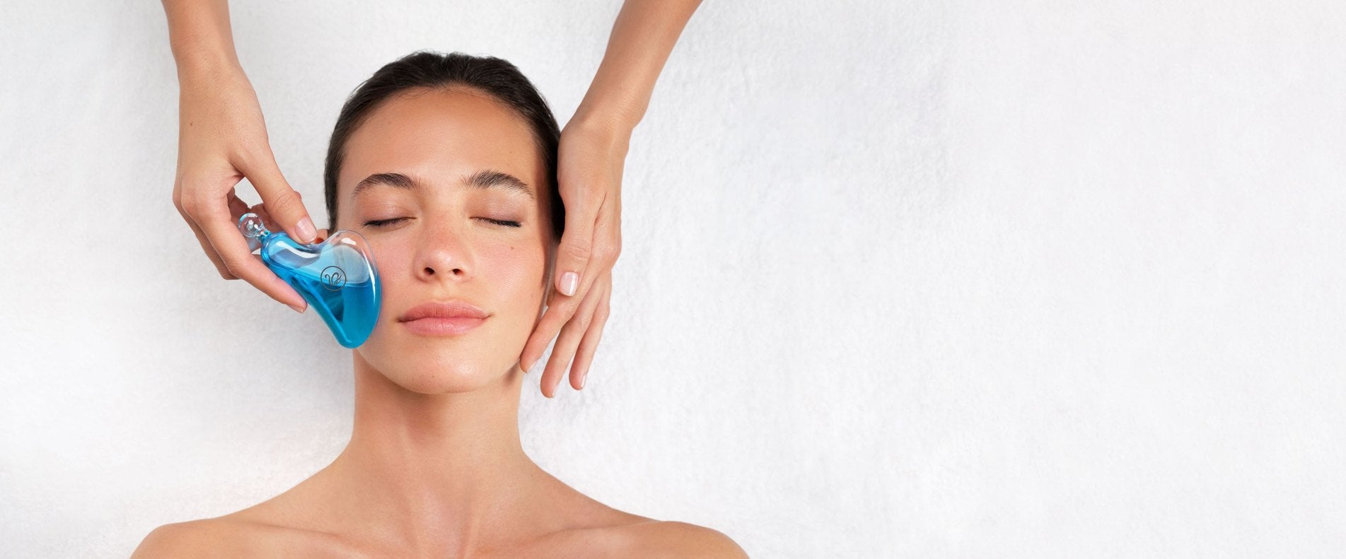 Professionista che applica il Cool Massager in vetro raffreddato sul viso di una cliente