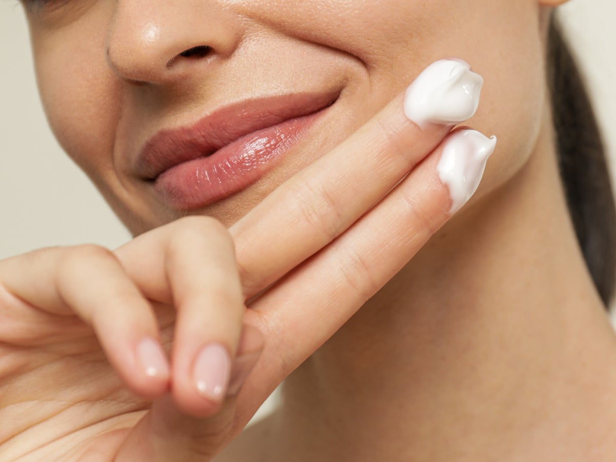 Mujer aplicandose crema en el rostro